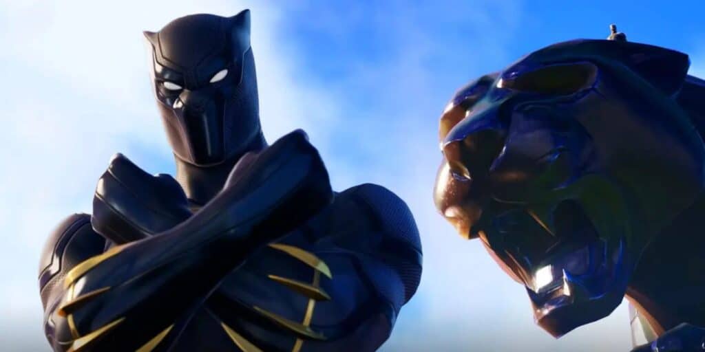Black Panther stands confidently beside a large, roaring panther statue against a vibrant blue sky