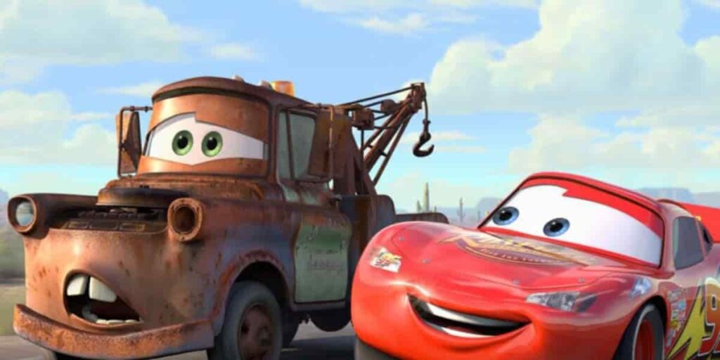 Lightning McQueen, a bright red race car, smiles alongside Mater, a rusty tow truck, against a sunny desert backdrop.