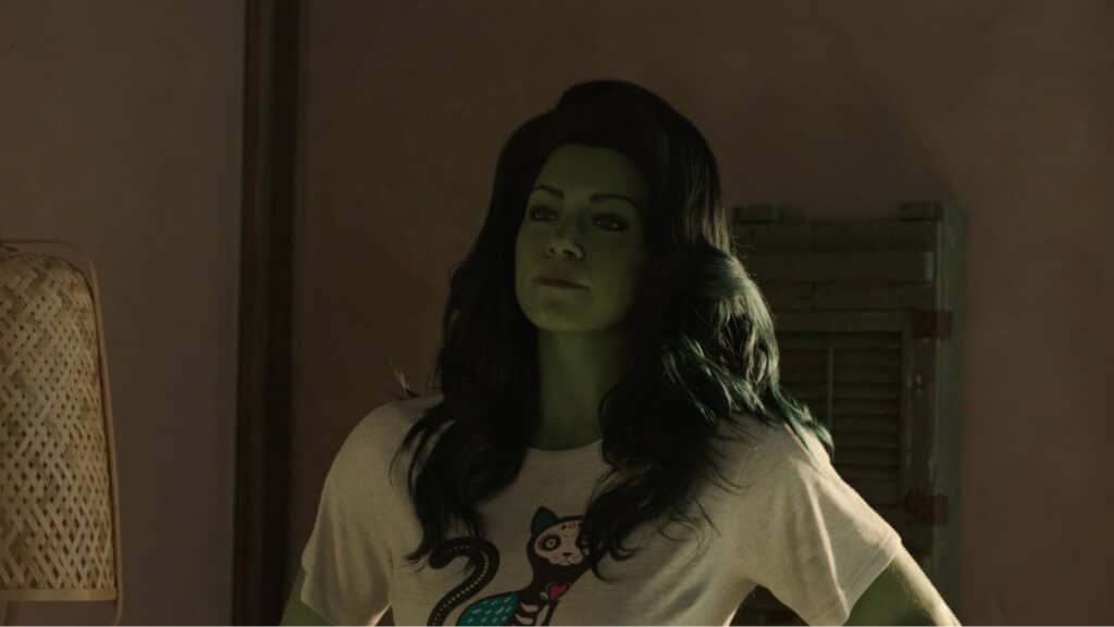 She-Hulk stands confidently in a dim room