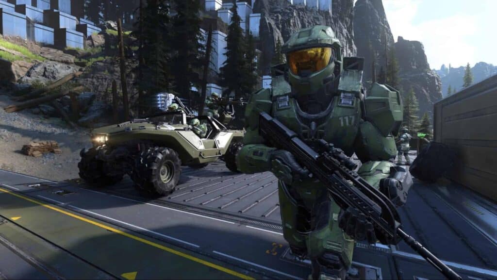 Master Chief armed with rifle beside Warthog in Halo Infinite