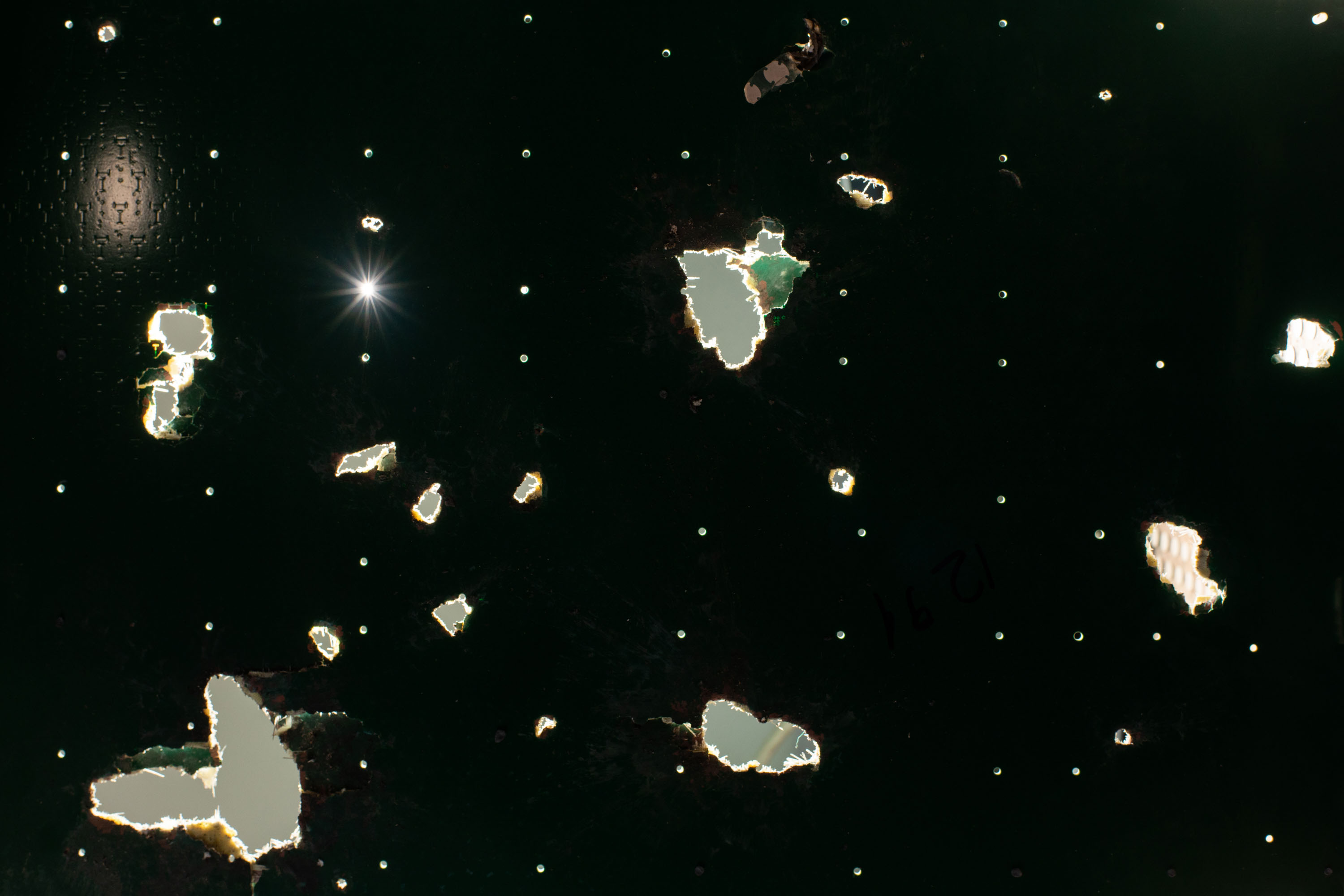 closeup of a Starlink board with light shining through the holes