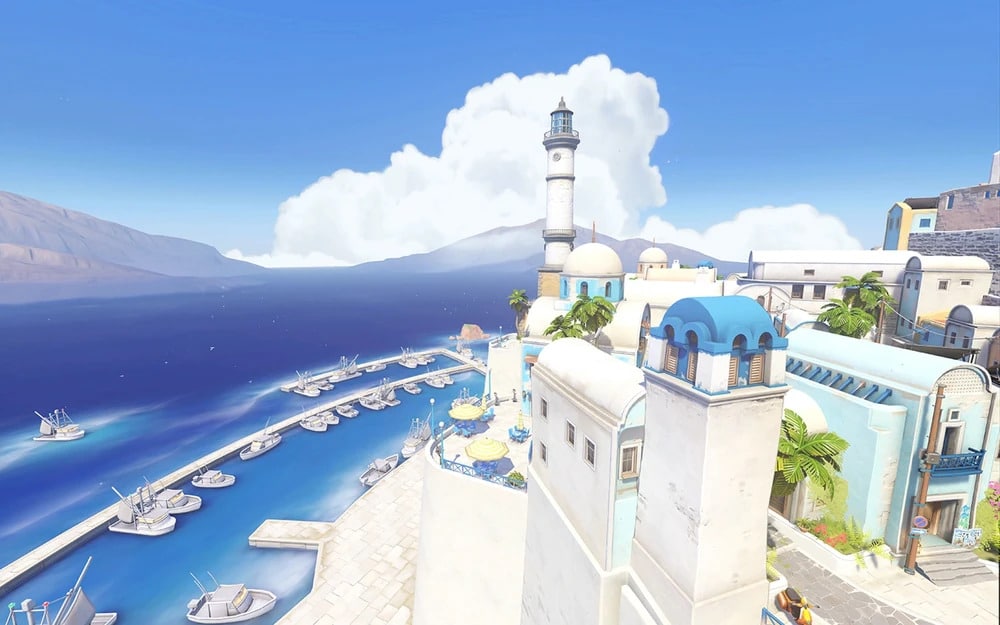 Scenic coastal view with white buildings, blue domes, and a lighthouse overlooking a vibrant blue sea