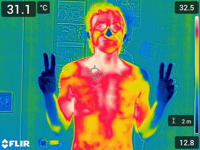 A thermal image shows a human male holding up peace signs during a test of extreme temperatures.